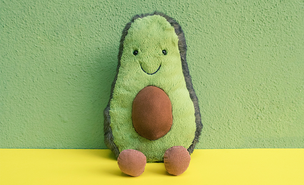 A stuffed, smiling avocado toy